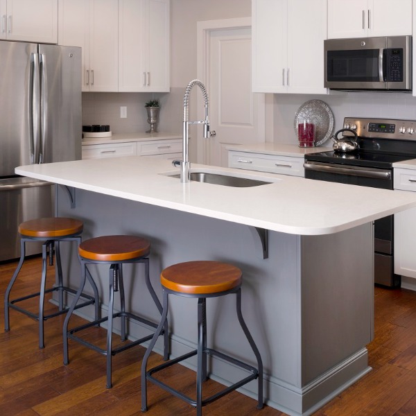 Simple kitchen design with grey island and white cabinets with stainless appliances - Marsh Kitchens.