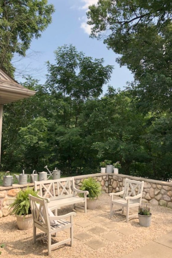 My French farmhouse inspired courtyard in summer with pea gravel, ferns, galvanized buckets, and boxwood - Hello Lovely Studio.