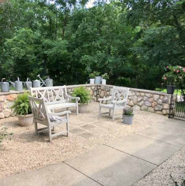 My Farmhouse French inspired courtyard in summer with pea gravel, ferns, galvanized buckets, and boxwood - Hello Lovely Studio.