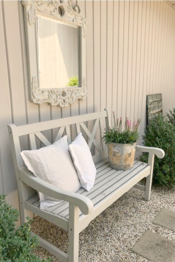 My French farmhouse inspired courtyard in summer with pea gravel, ferns, galvanized buckets, and boxwood - Hello Lovely Studio.