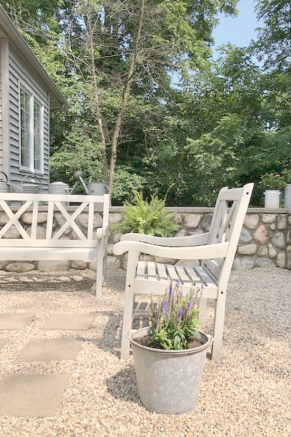 My Farmhouse French inspired courtyard in summer with pea gravel, ferns, galvanized buckets, and boxwood - Hello Lovely Studio.