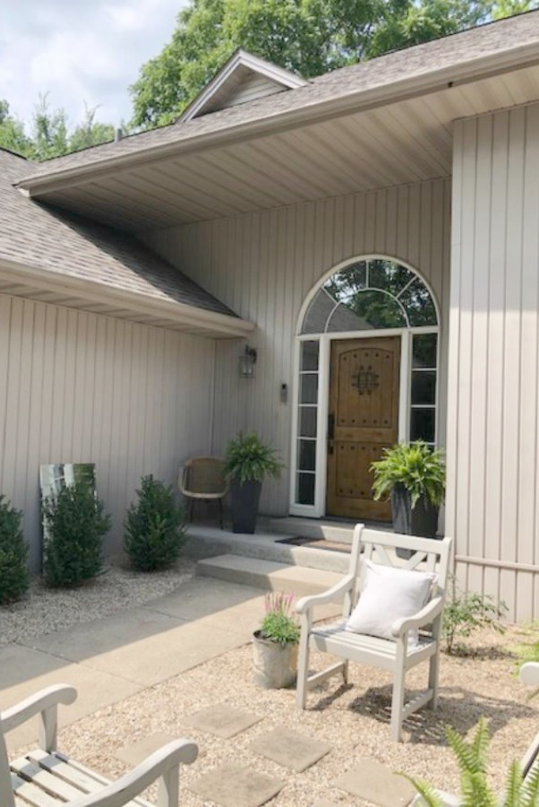 My Farmhouse French inspired courtyard in summer with pea gravel, ferns, galvanized buckets, and boxwood - Hello Lovely Studio.