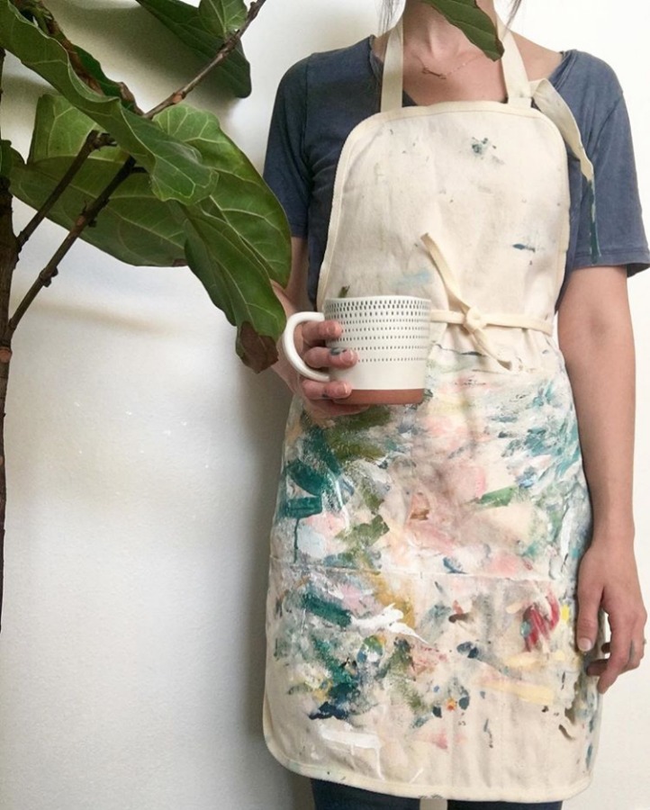 Artist Rebekah May in a painting smock.