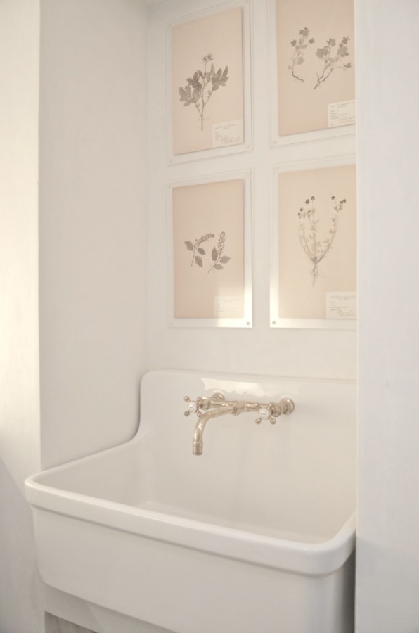 A gorgeous farm sink with wall mount faucet ina beautiful French farmhouse style laundry room at Patina Farm by Brooke Giannetti.