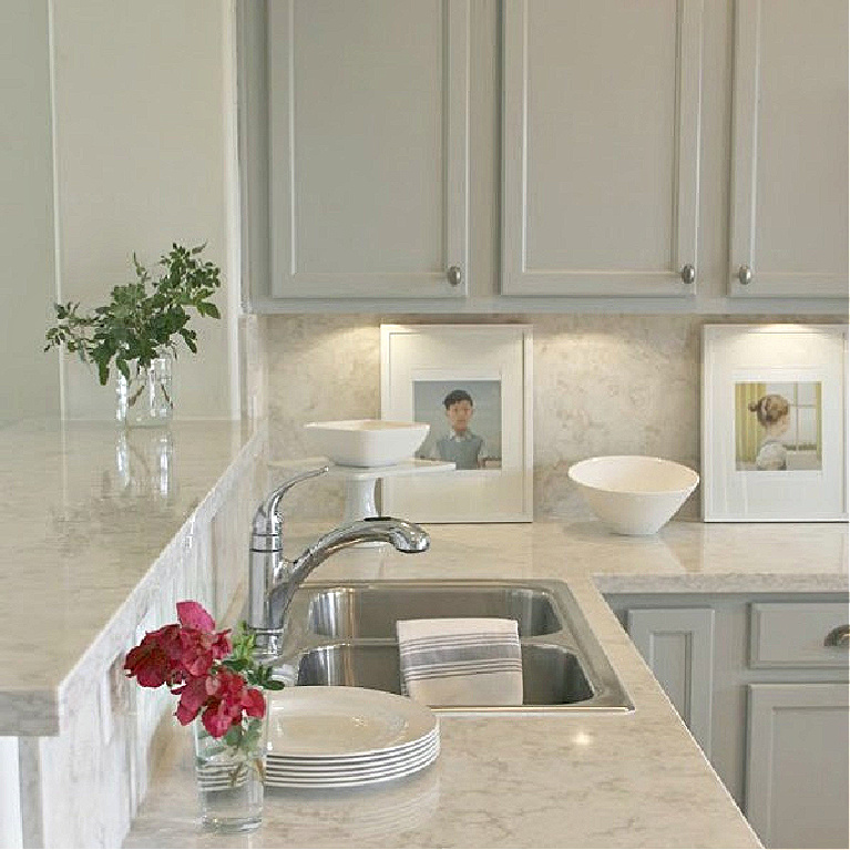 Serene kitchen makeover with Viatera white quartz (Soprano), painted cabinets (Behr Classic Silver), hardware (Top Knobs), and Kitchenaid Smudgeproof appliances - Hello Lovely Studio. #kitchenmakeover #beforeafter #diykitchenreno #kitchendesign #paintedcabinets #viateraquartz #soprano #homereno