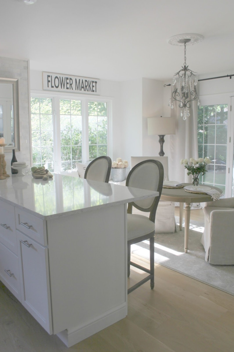 Hello Lovely's serene white French country and European inspired kitchen with window seat and Belgian linen accents. Find a Soft, Ethereal European Country Kitchen Mood to Inspire Now!