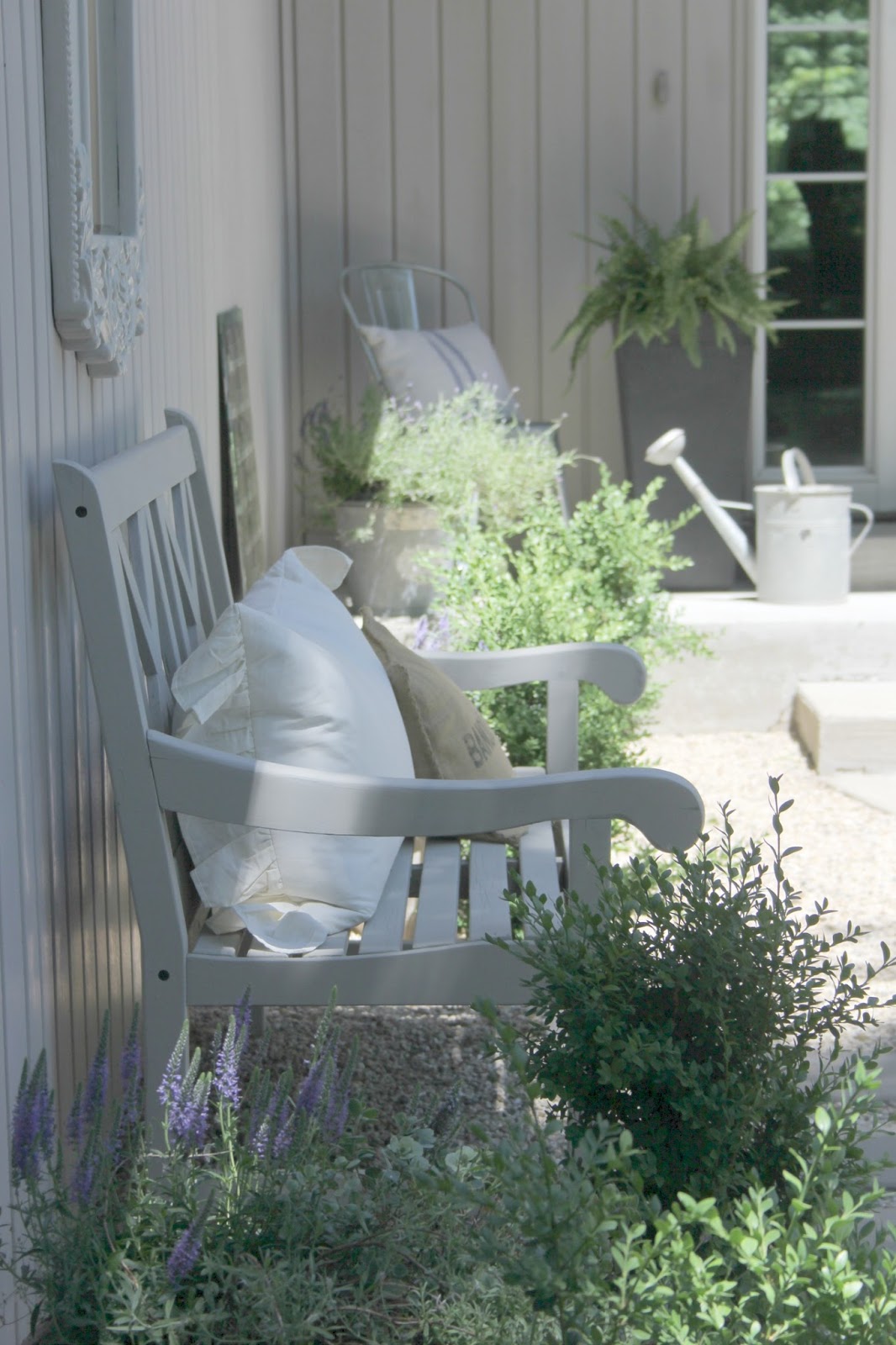 French farmhouse inspired courtyard with pea gravel, wood furniture, and vintage galvanized buckets. #hellolovelystudio #gardens #courtyards #frenchfarmhouse #peagravel #outdoorfurniture #outdoordecor