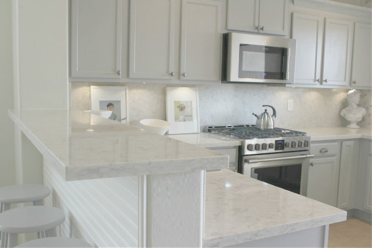 Viatera Soprano quartz kitchen counters and backsplash with Behr Classic Silver painted blue grey cabinets - Hello Lovely Studio. #viateraquartz #soprano #bluegreykitchen #kitchendesign #kitchenmakeover #serenekitchen #behrclassicsilver