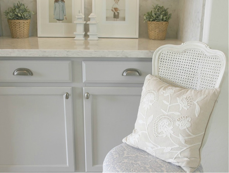 Serene kitchen makeover with Viatera white quartz (Soprano), painted cabinets (Behr Classic Silver), hardware (Top Knobs), and Kitchenaid Smudgeproof appliances - Hello Lovely Studio. #kitchenmakeover #beforeafter #diykitchenreno #kitchendesign #paintedcabinets #viateraquartz #soprano #homereno