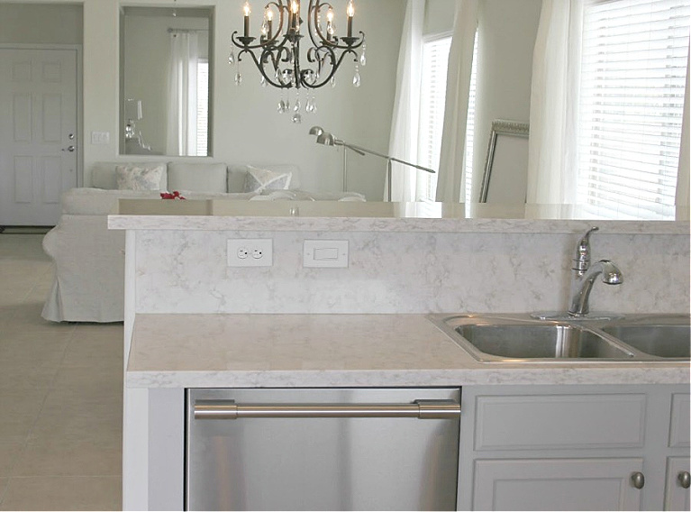 Serene kitchen makeover with Viatera white quartz (Soprano), painted cabinets (Behr Classic Silver), hardware (Top Knobs), and Kitchenaid Smudgeproof appliances - Hello Lovely Studio. #kitchenmakeover #beforeafter #diykitchenreno #kitchendesign #paintedcabinets #viateraquartz #soprano #homereno