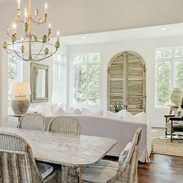 Modern French country style in a white living room and dining room with rustic wood accents and antiques. Come see more white country interiors and score tips for stealing the look.