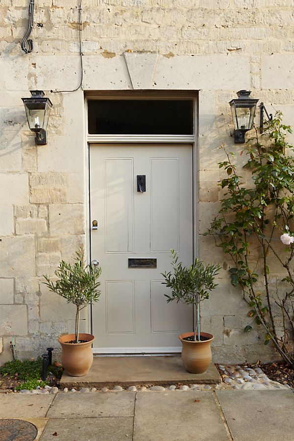 Farrow & Ball Stony Ground paint color on front door of a gorgeous tone home. Come score ideas for 16 Amazing Serene Paint Colors Interior Designers Use for a Soothing Vibe.