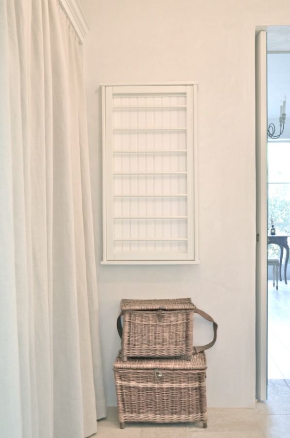 Patina Farm laundry room with rustic french farmhouse baskets, on the wall drying rack, and plaster walls. Design: Giannetti Home and photo via Velvet and Linen.