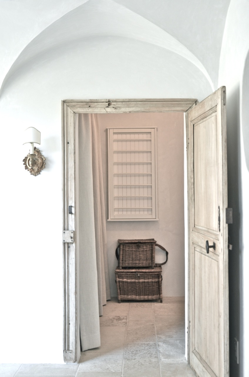 Patina Farm laundry room with rustic french farmhouse baskets, on the wall drying rack, and plaster walls. Design: Giannetti Home and photo via Velvet and Linen.