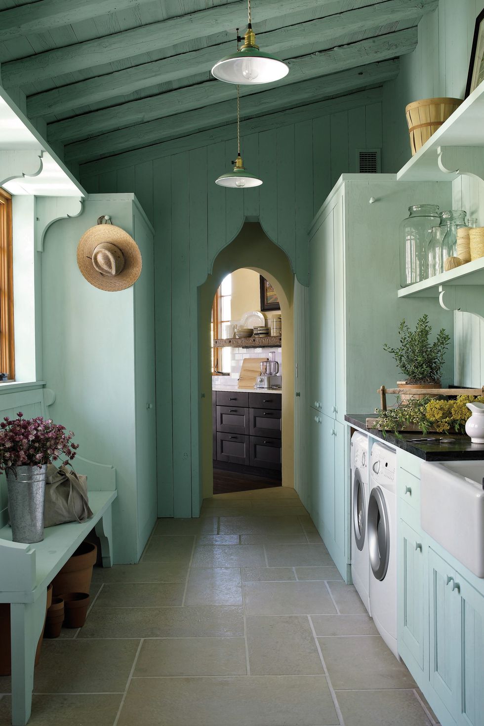 Breathtaking architecture and green color in a laundry room by architect Michael Imber - come enjoy more Dreamy Laundry Room Inspiration to Re-imagine a Timeless Tranquil Design!