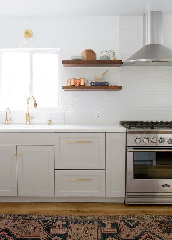 This serene and classic kitchen with modern minimal style by Lauren Bradshaw sports cabinets painted Farrow & Ball Pavilion Gray.