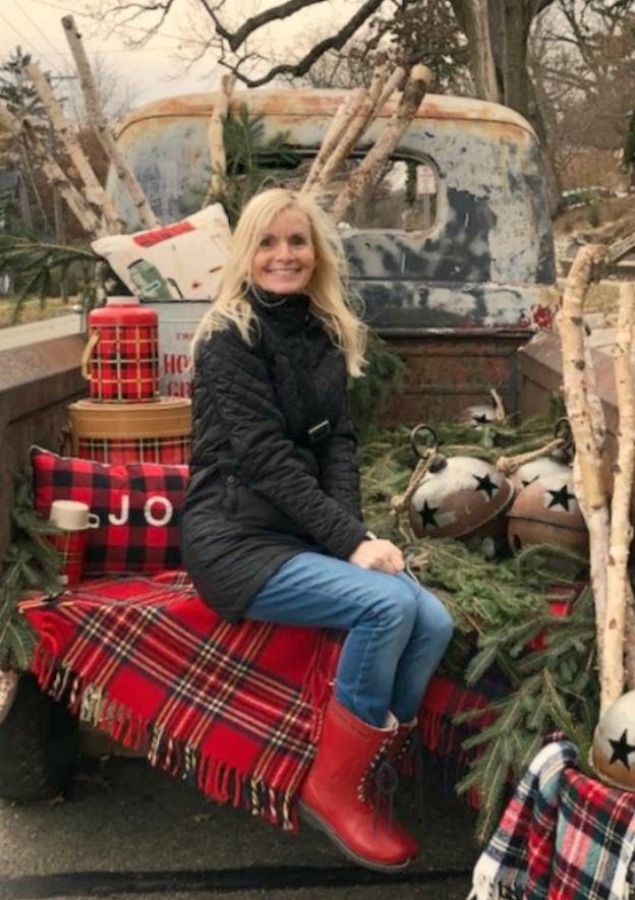 Michele on a vintage pickup truck with holiday farmhouse decor at Urban Farmgirl - Hello Lovely Studio.