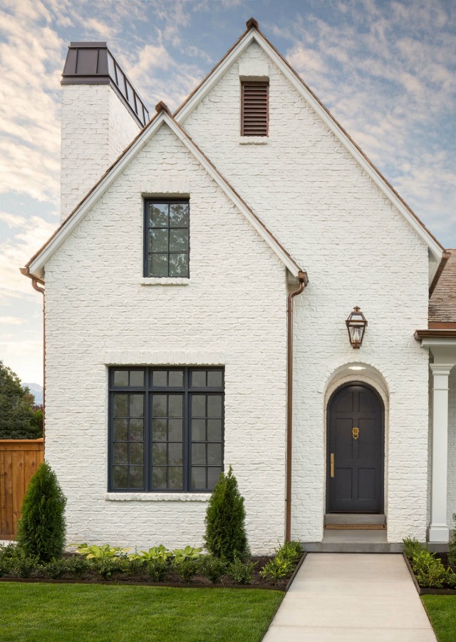 For a similar white paint color for brick, try Benjamin Moore Simply White. White painted brick beautiful home exterior by The Fox Group.