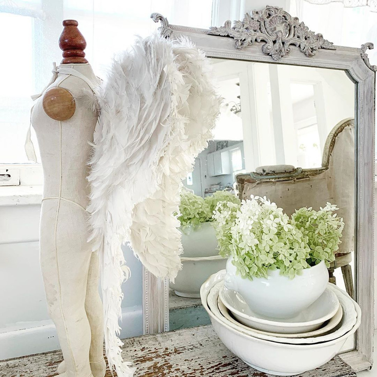 Serene and breathtaking French Nordic white child's angel wings styled in a vignette with antique mirror and ironstone - My Petite Maison.