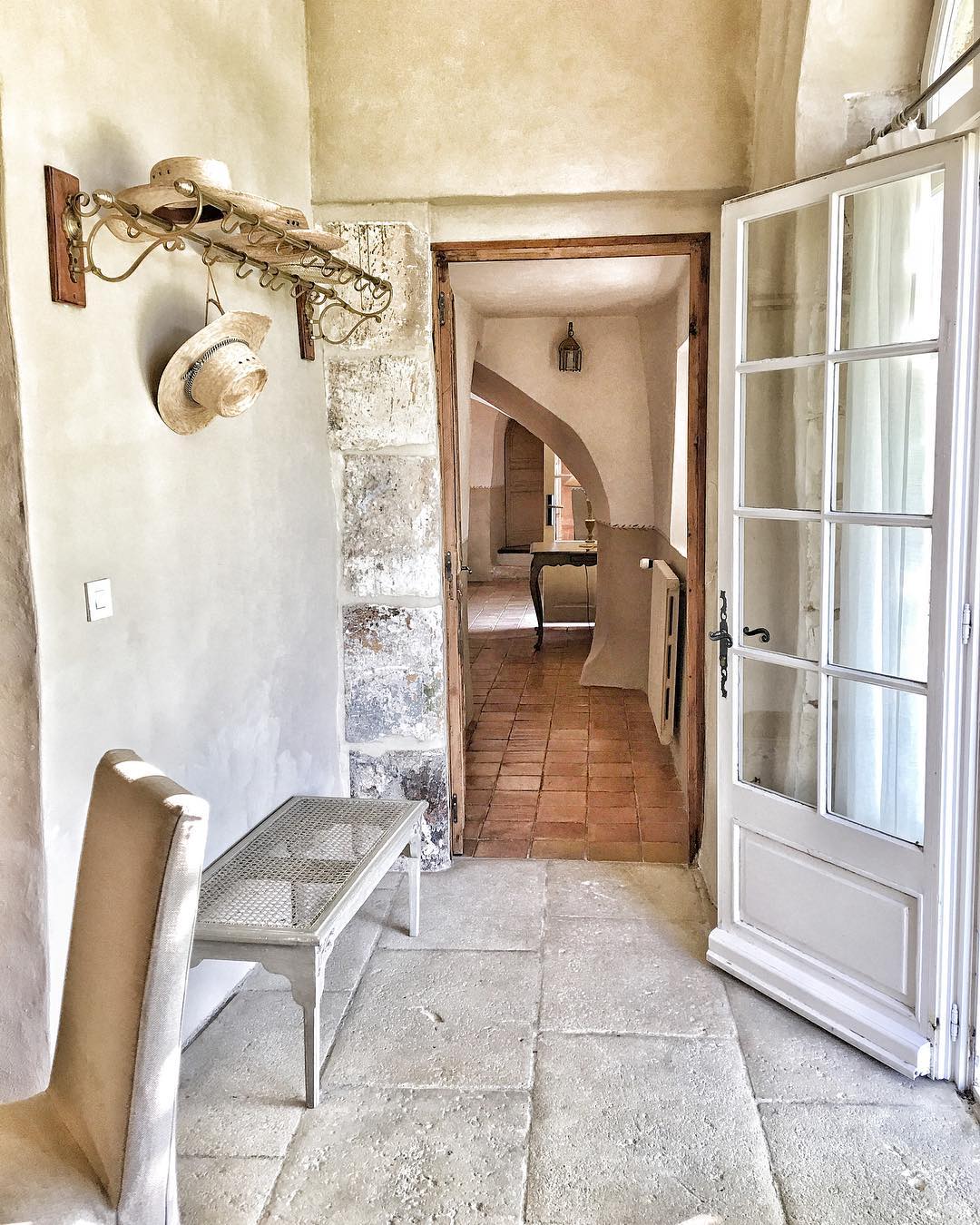 French farmhouse in France entry with coat rack and charming rustic decor. Photo by Vivi et Margot.