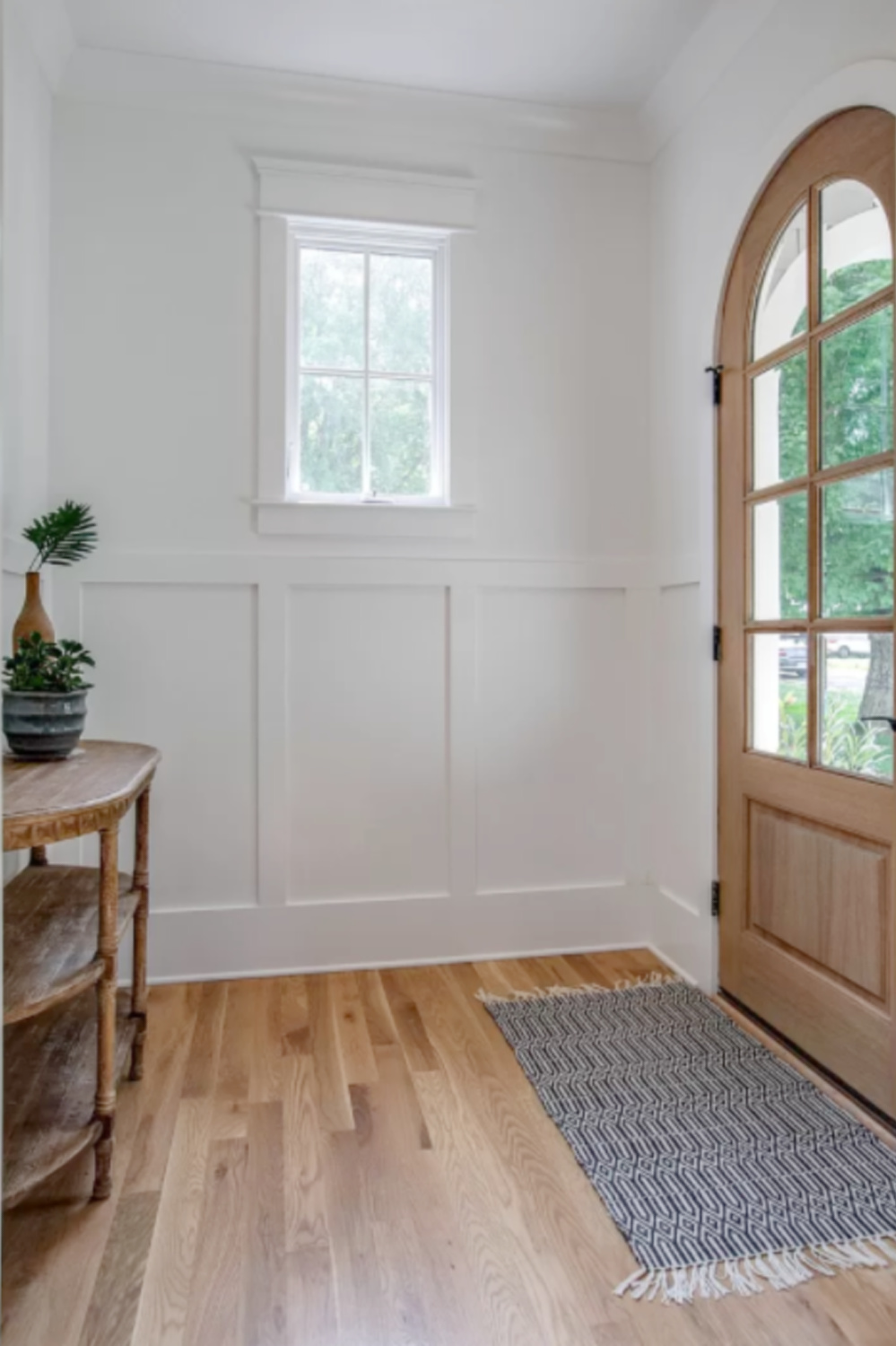 Arched wood front door and board an batten wall in entry of a charming Franklin, TN cottage. #entry #interiordesign