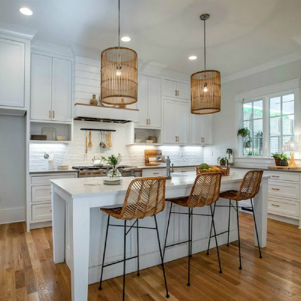 Breezy white Shaker kitchen with natural organic woven pendants and counter stools in a Tennessee cottage. #beachykitchen #shakerkitchen