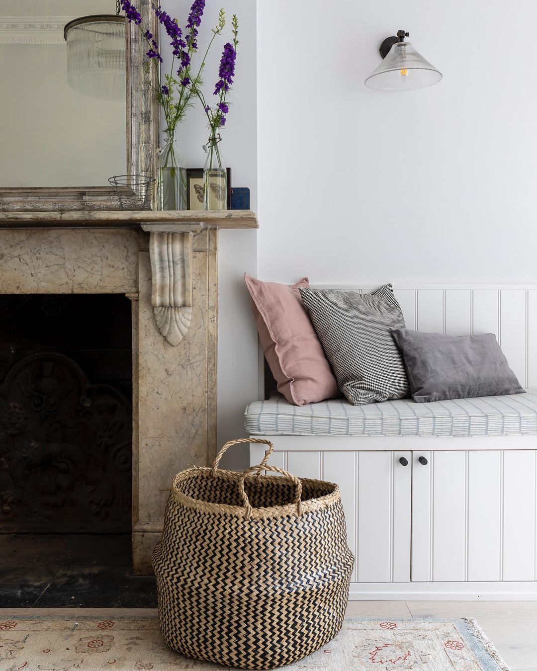 Detail of an antique marble fireplace, antique rug, and built-in bench in a beautifully designed space by Imperfect Interiors. #fireplace #antiques #interiordesign #serenedecor #englishcountry