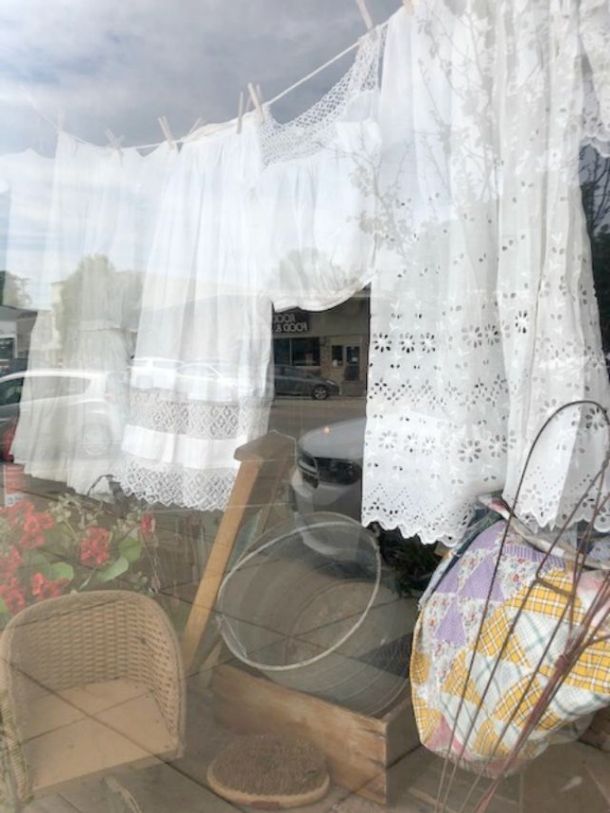 Charming clothesline in a shop window!Rustic farmhouse decor, vintage flea market treasures, and LOVELY Fall and Autumn inspiration are flowing as I take you shopping with me for country goodness in the Northern Illinois and Southern Wisconsin. Hello Lovely Studio. #farmhousestyle #rusticdecor #countryhomes #fleamarket