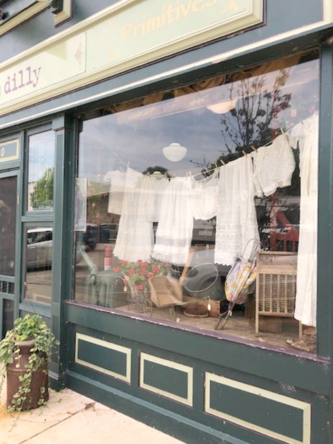 Charming clothesline in a shop window! Rustic farmhouse decor, vintage flea market treasures, and LOVELY Fall and Autumn inspiration are flowing as I take you shopping with me for country goodness in the Northern Illinois and Southern Wisconsin. Hello Lovely Studio. #farmhousestyle #rusticdecor #countryhomes #fleamarket