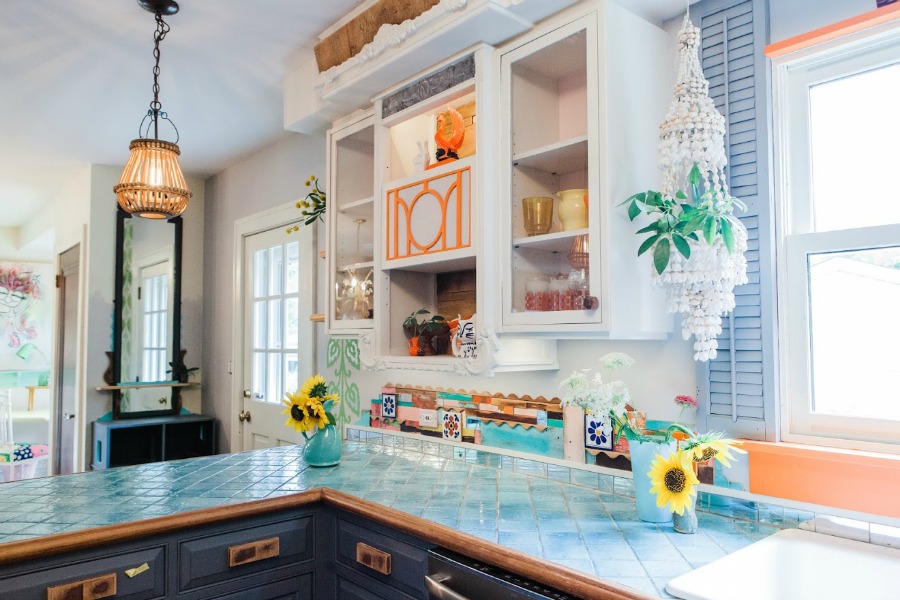 Turquoise, orange, green, and teal in a kitchen. Be inspired by this photo gallery of vibrant colorful beachy boho interior design from artist Jenny Sweeney's Chicagoland home. Her art has been lifting spirits and opening hearts to wonder - see how it lives large in a charming suburban Tudor!