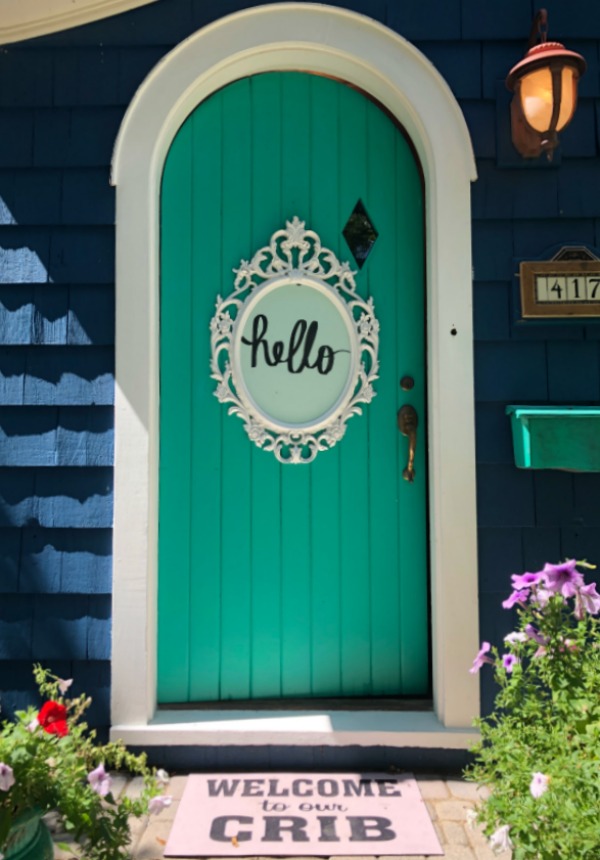 Arched front door of Tudor. Be inspired by this photo gallery of vibrant colorful beachy boho interior design from artist Jenny Sweeney's Chicagoland home. Her art has been lifting spirits and opening hearts to wonder - see how it lives large in a charming suburban Tudor!