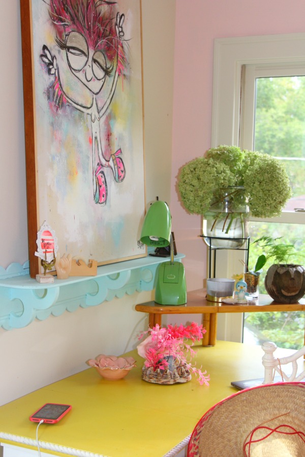 Candy pink painted walls, whimsical art, and colorful vintage treasures mix in an office nook by Jenny Sweeney. #desk #colorfuldecor #vintagestyle #pinkwalls