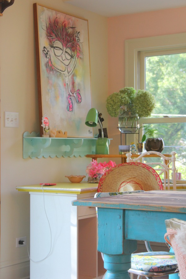 Candy pink painted walls, whimsical art, and colorful vintage treasures mix in an office nook by Jenny Sweeney. #desk #colorfuldecor #vintagestyle #pinkwalls
