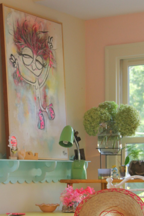 Candy pink painted walls, whimsical art, and colorful vintage treasures mix in an office nook by Jenny Sweeney. #desk #colorfuldecor #vintagestyle #pinkwalls