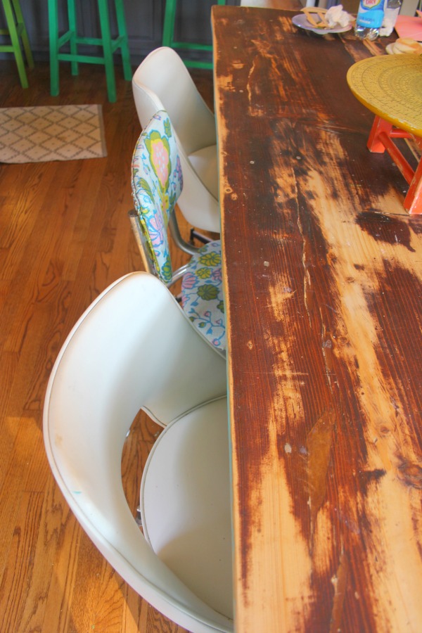 Vintage chairs and a rustic farm table in the dining room of a cottage designed by Jenny Sweeney.