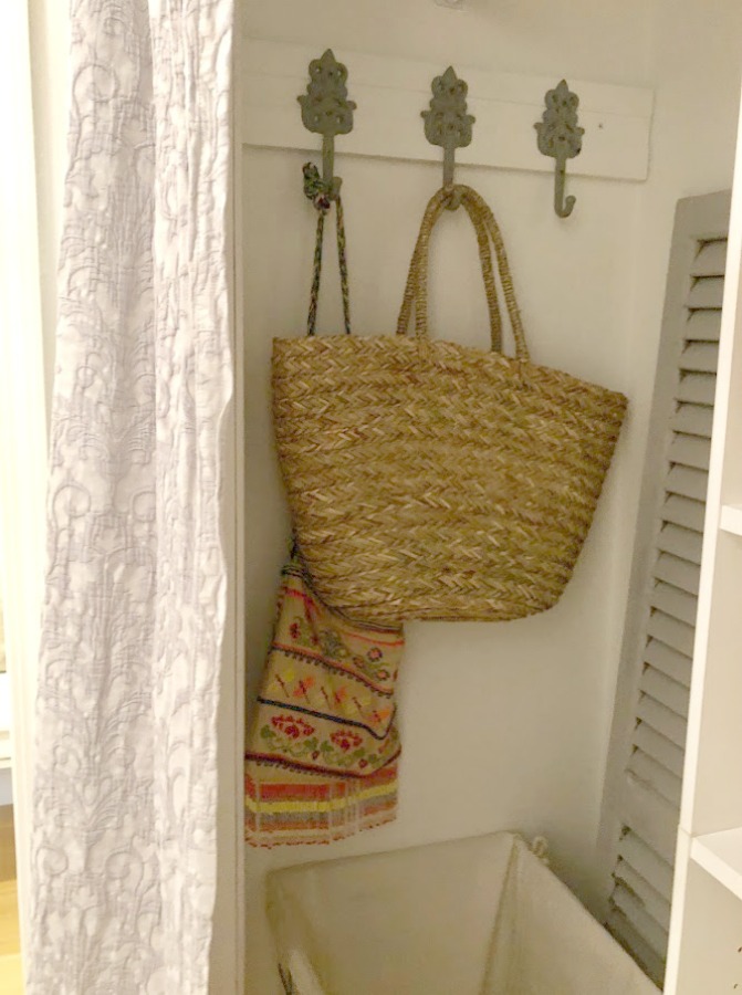 Come see how I made our awful little pass through laundry room next to the garage function better and look peaceful with simple inexpensive DIY - Hello Lovely Studio. #beforeafter #laundryroom #diy #makeover #serenedecor