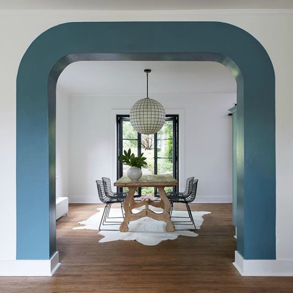 Blue Blood PPG paint color is used as a unique stripe around an archway in a dining room on HGTV;s Restored by the Fords with design by Leanne Ford. #blueblood #ppg #paintcolors #interiordesign #leanneford #restoredbythefords #diningroom #stripe