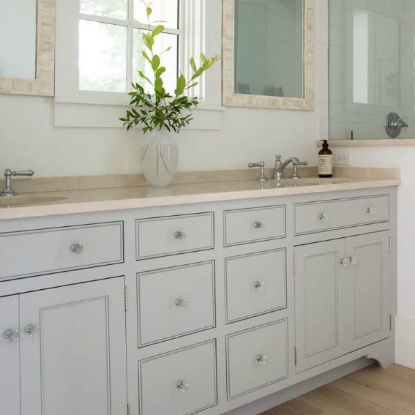 This bathroom vanity in a coastal cottage is painted Tinsmith by Sherwin Williams. Designed by Lisa Furey.Click through for Perfect Light Gray Paint Colors You'll Love as Well as Interior Design Inspiration Photos. #bestgreypaint #paintcolors