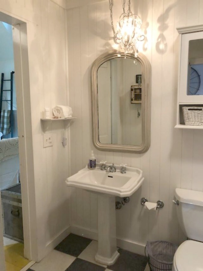 Serene and peaceful, this cottage bedroom with vintage style at Storybook Cottage (Leiper's Fork, TN) was designed by Kim Leggett of City Farmhouse. #farmhousestyle #storybookcottage #cityfarmhouse #bathroom #countrybathroom