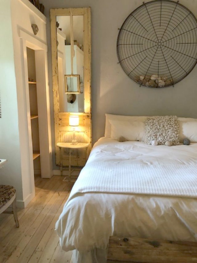 Serene and peaceful, this cottage bedroom with farmhouse style and vintage furniture at Storybook Cottage (Leiper's Fork, TN) was designed by Kim Leggett of City Farmhouse. #farmhousestyle #storybookcottage #cityfarmhouse #bedroom #farmhousebedroom