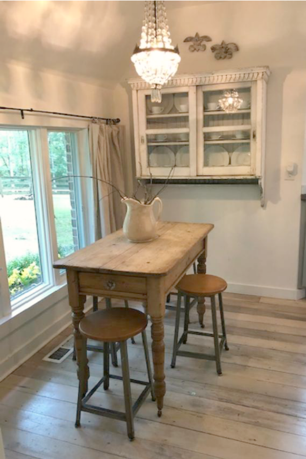 From the blue grey cabinet doors with cross cut out detail to the open shelving, this farmhouse kitchen designed by City Farmhouse for Storybook Cottage in Leiper's Fork, TN, sings with vintage country style! Photo by Hello Lovely Studio. #farmhousekitchen #cityfarmhouse #storybookcottage