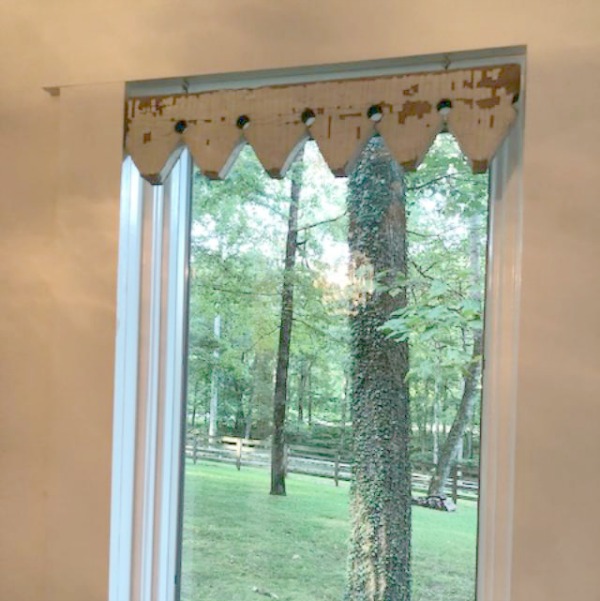 Detail of architectural salvage trim used as window treatment in farmhouse kitchen at Storybook Cottage.