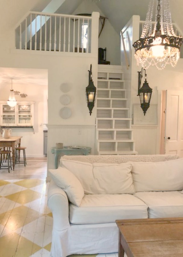 Farmhouse chic living room with vintage treasures, bold yellow painted poplar wood flooring, linen upholstery, and design by City Farmhouse for Storybook Cottage in Leiper's Fork, TN - Hello Lovely Studio. #farmhousestyle #livingroom #cityfarmhouse #storybookcottage