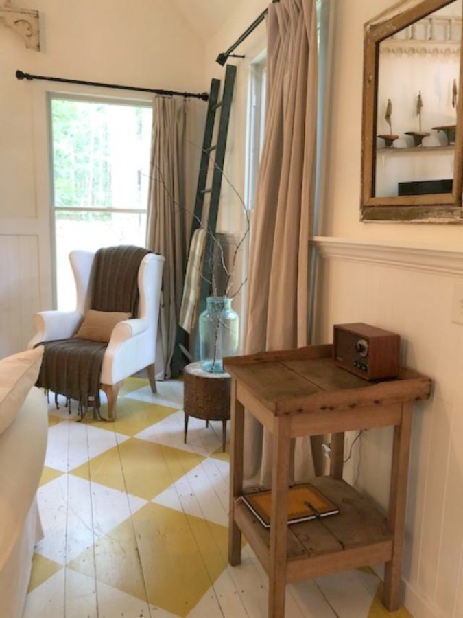Farmhouse charm and vintage style in a charming entry with white paneling and bold yellow painted poplar floors greeting you at Storybook Cottage in Leiper's Fork near Franklin, TN. The interiors designed by Kim Leggett of City Farmhouse inspire! #farmhousedecor #storybookcottage #entry