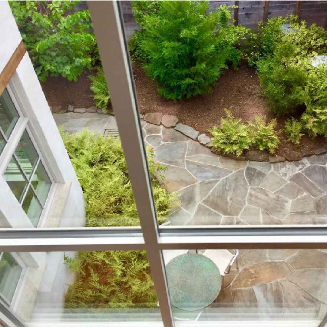 View of patio and garden from a magnificent traditional Houston home by architect Kelly Cusimano and crafted by Marcellus Barone of Southampton Homes. #belgianartchitecture #houseexterior #oldworld #minimal