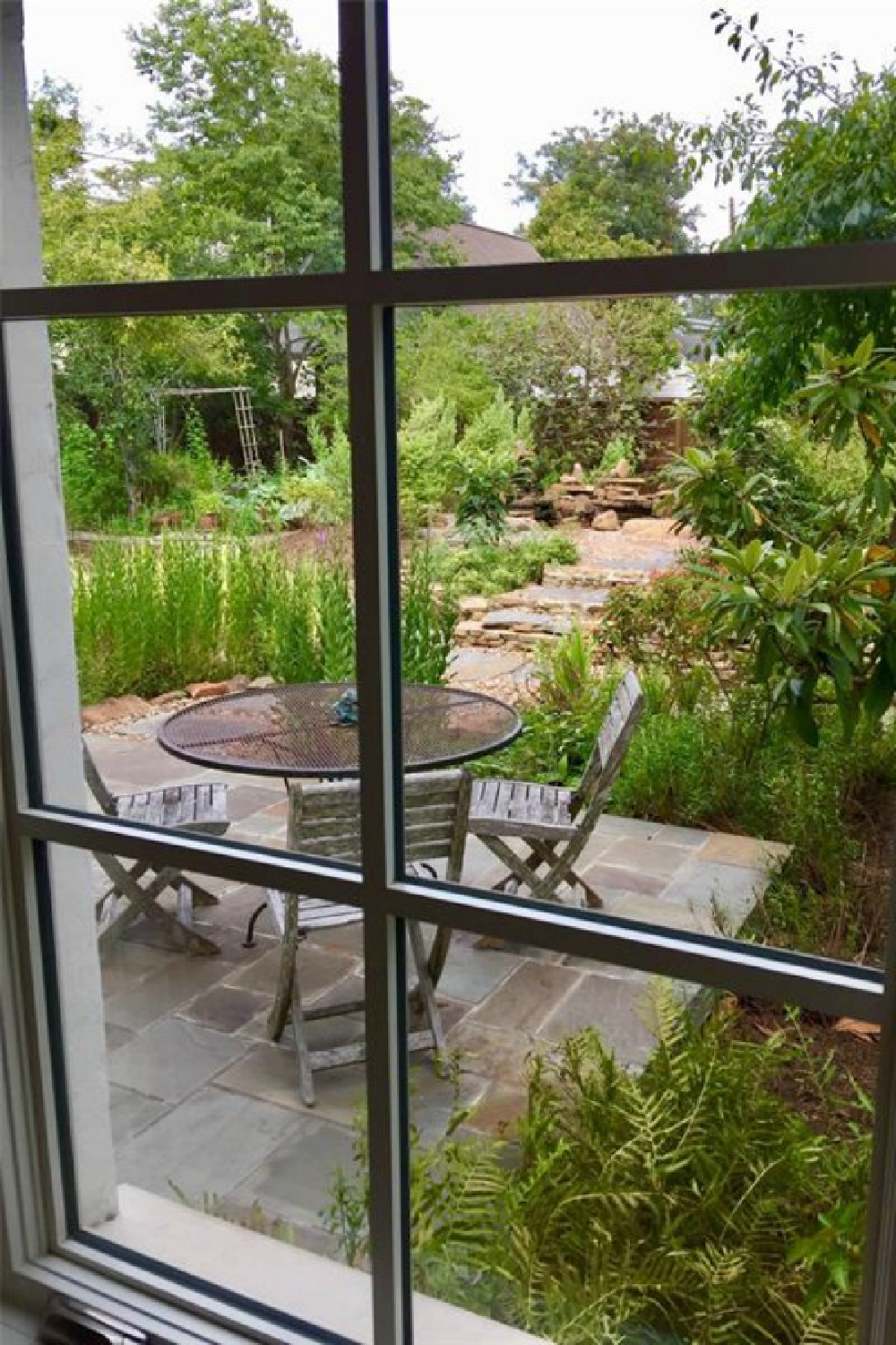 View of patio and garden from a magnificent traditional Houston home by architect Kelly Cusimano and crafted by Marcellus Barone of Southampton Homes. #belgianartchitecture #houseexterior #oldworld #minimal