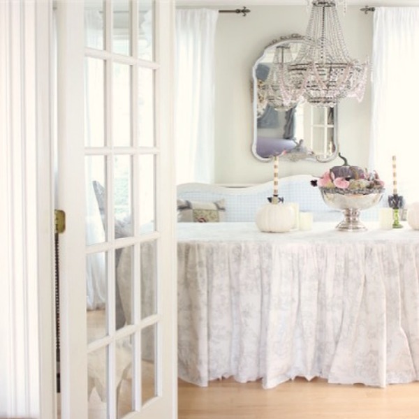 Romantic French charm abounds in a dining room with a custom toile skirted table and Empire style crystal chandelier - Maison Decor. #frenchcountry #diningroom #interiordesign #skirtedtable #romanticdecor #cyrstalchandelier