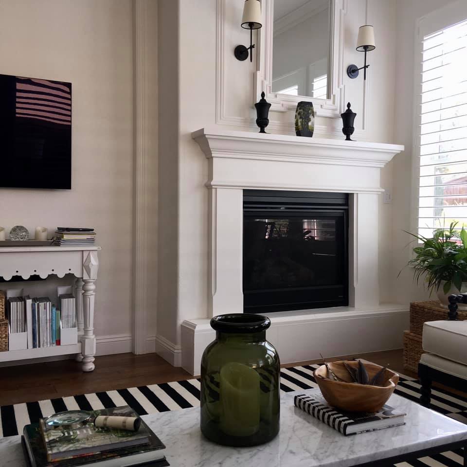 Classic living room with black and white stripe rug and beautiful white framed fireplace - Good Life of Design. #livingrooms #livingroomdecor #blackandwhite