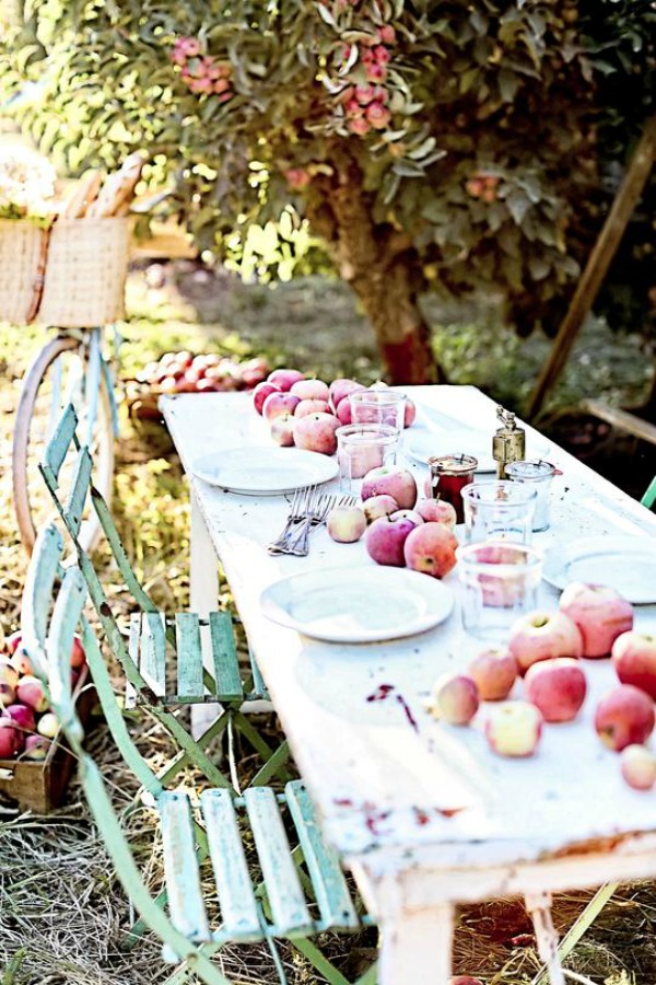 What a dreamy picture of French farmhouse fall bliss in this outdoor dining vignette with farm table and bistro chairs - Dreamy Whites Atelier. Serene French Farmhouse Fall Decor Photos ahead! #frenchfarmhouse #fallinspiration #apples #harvest #farmtable