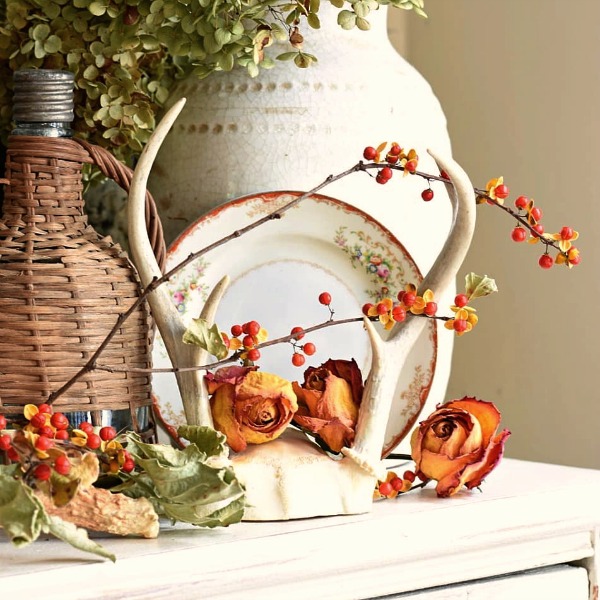 A French Country fall vignette with bitterroot, urns, and French vintner's basket pulls on the heartstrings and feels warm and charming - Follow the Yellow Brick Home. #frenchcountry #interiordesign #stilllife #falldecor #bitterroot #vintnerbasket